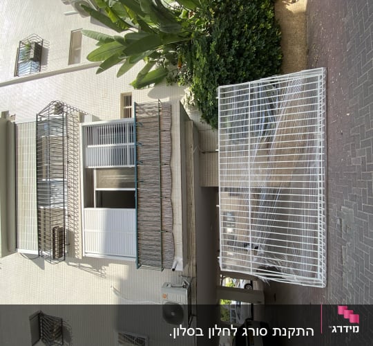 מסגרת מתכת לבנה מונחת על הקרקע ליד בניין